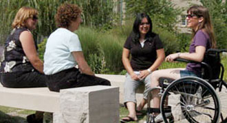 Four people sitting and talking outside